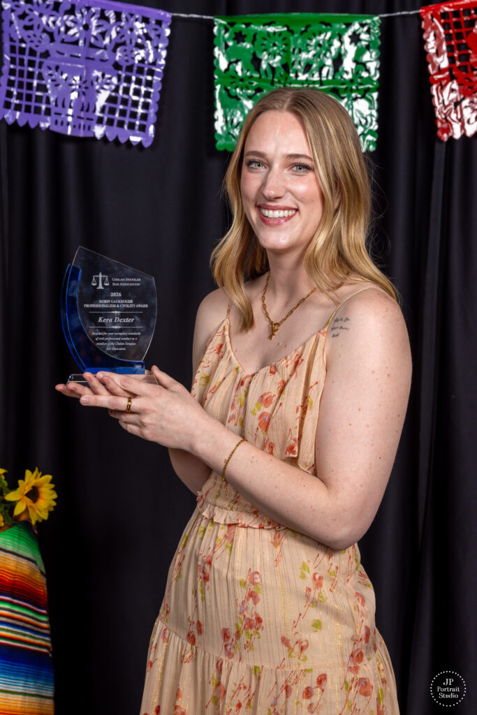 Kera Dexter is the recipient of the Robin Gaukroger Professionalism and Civility Award. She is wearing a light yellow dress with flowers and holding the award.